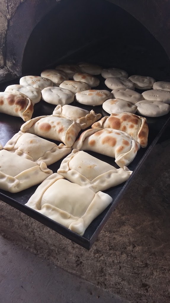 Empanadas y pan en el horno de barro de Angie